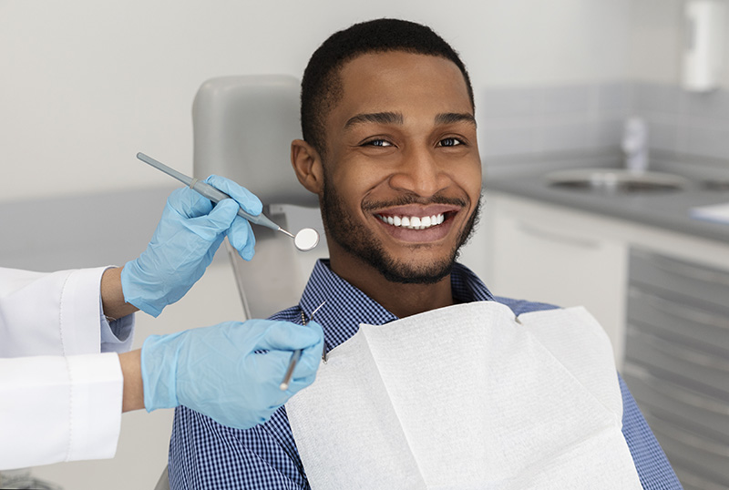 man smiling while receiving dental care